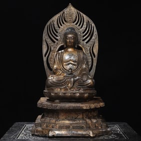 A statue of Shakyamuni with copper clay and gold backlight