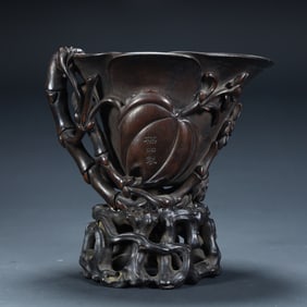 A Qing Dynasty rosewood (or mahogany) carved "longevity peach bamboo branch pattern" cup