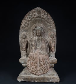 A statue of three statues of one Buddha and two disciples in the stone back screen of the Northern