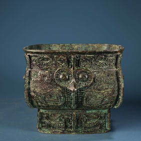 A bronze bird-faced square bucket