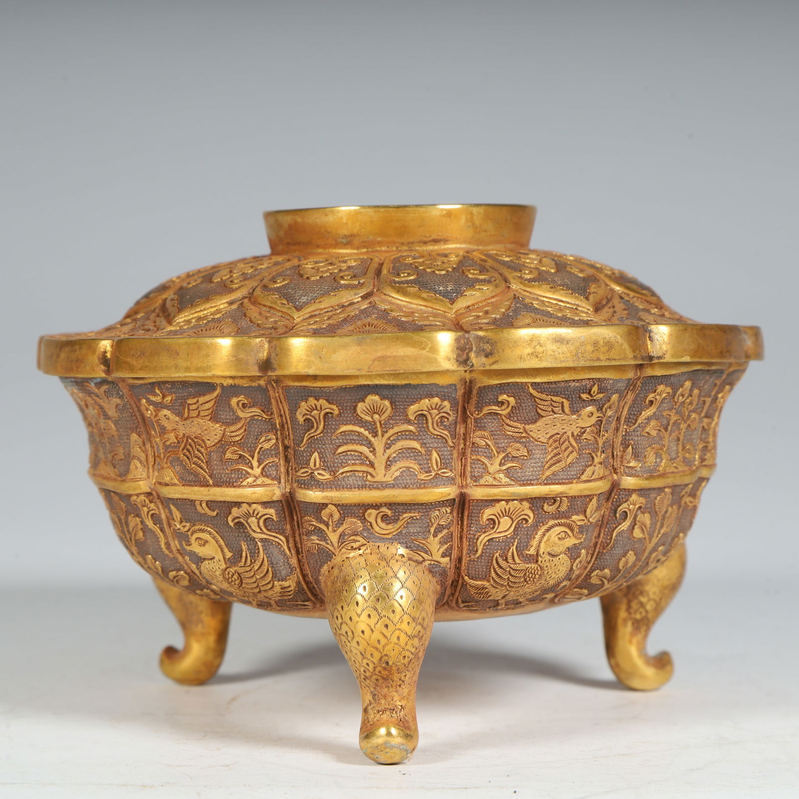 A Tang Dynasty engraved pearl ground lotus petal bird and beast pattern three-legged gold bell (1 of 10)