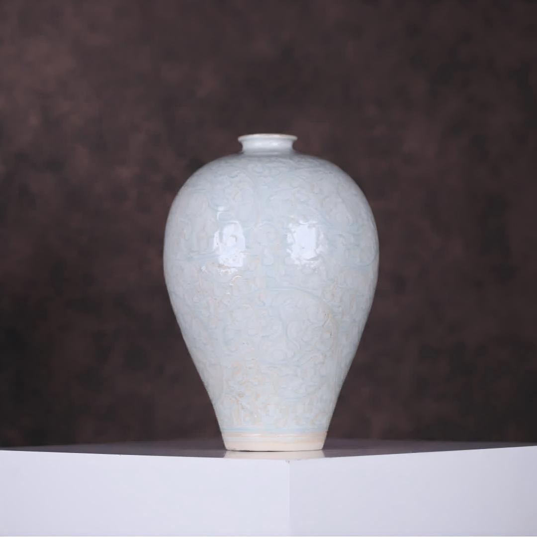 A Song Hutian kiln shadow celadon carved curl grass pattern plum bottle: Song Hutian kiln shadow celadon carved grass pattern plum bottle Continuing the classic shape of the Song Dynasty plum bottle small mouth short neck full shoulders full of abdomen Circle feet The