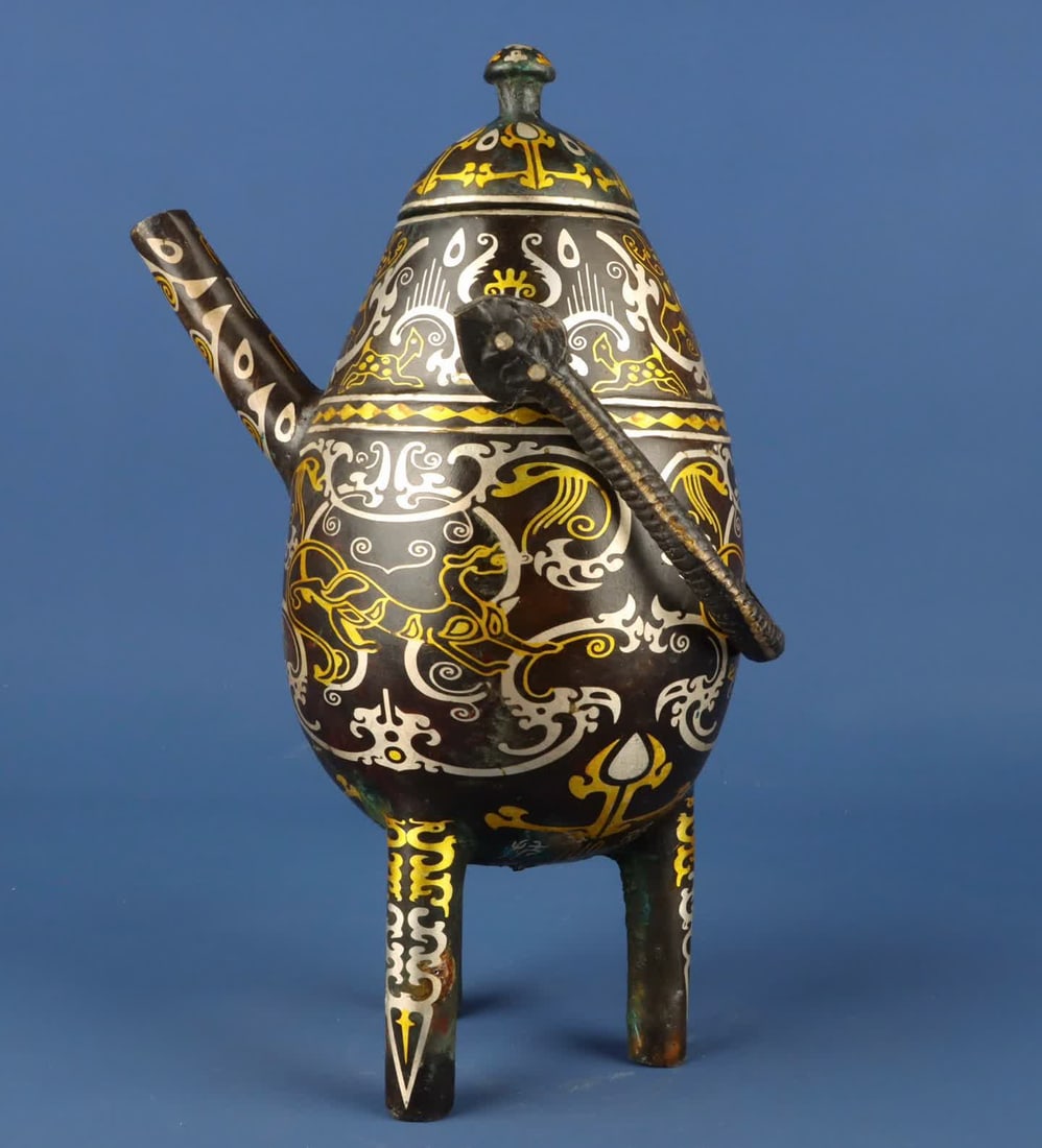 A piece of Han Dynasty_Bronze Cuojin and silver three-legged beam: Han Dynasty_Bronze Cuo gold and silver three-legged beam SIZE: W:2200g L:19cm H:33cm (The Dimensions Of All Batches Are Manually Measured.If You Need More Detailed Information, Please Contact Our