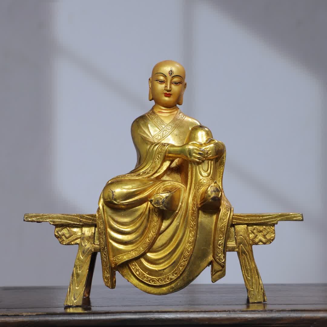 A statue of a Buddha statue on a copper gilt painted bench (1 of 9)