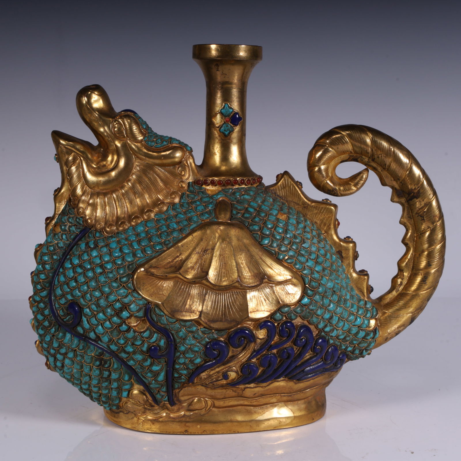A copper-gilt turquoise Capricorn pot: It is a copper-gilt turquoise Capricorn pot, shaped like Capricorn (a mythical fish-shaped creature), the body is inlaid with turquoise, showing a fish-scale effect, and is also decorated with blue en