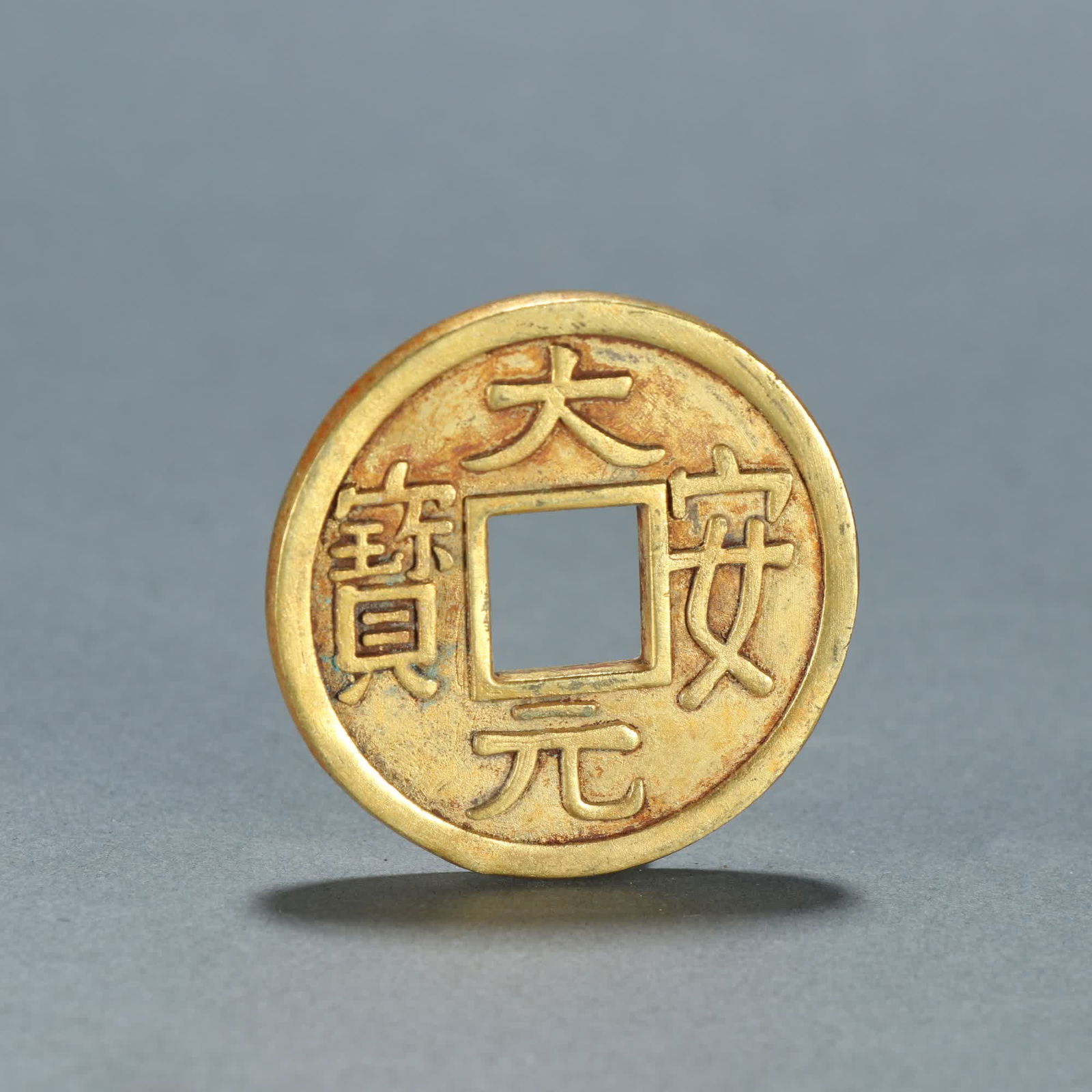 A Qing Dynasty Liao copper-gilt Da'an ingots cost money: Qing Dynasty Liao copper gilt Daan ingots spend money SIZE: D:4.4cm W:39.3g