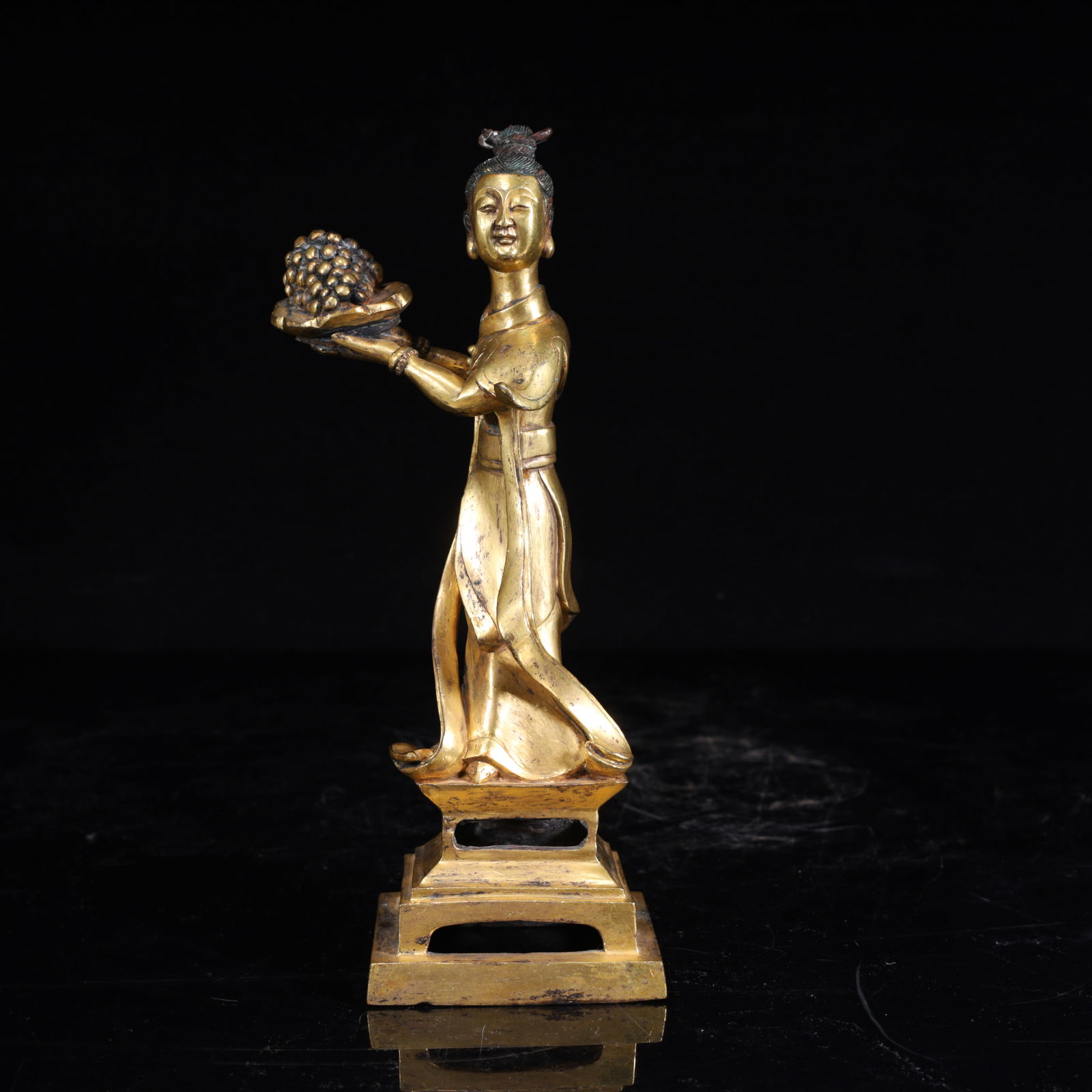 A statue of a bronze gilt maid in the Qing Dynasty offering fruit: The copper tire is gilded, shaped as a maid offering fruit (holding grapes), and the craftsmanship is delicate, which is a Qing Dynasty court or aristocratic furnishing utensil, reflecting the Qing Dy