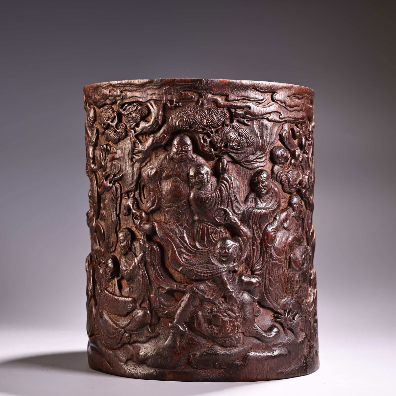 A Qing Dynasty agarwood high-relief engraving eighteen Arhat pen holder: In the Qing Dynasty, agarwood was collected with high relief engravings and engraved eighteen Arhat pen holders SIZE: W:1000g H:21cm D:17.5cm (The Dimensions Of All Batches Are Manually Measured.If Yo