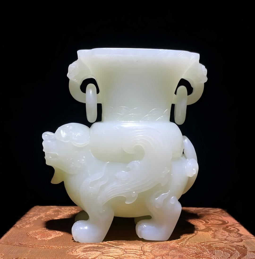 A Qing Dynasty Hetian jade auspicious beast cup ornament: Qing Dynasty Hetian jade auspicious beast cup ornament is carved from Hetian jade, the cup body is waist-open, the outside of the mouth is decorated with fine banana leaf patterns, and the lines are n
