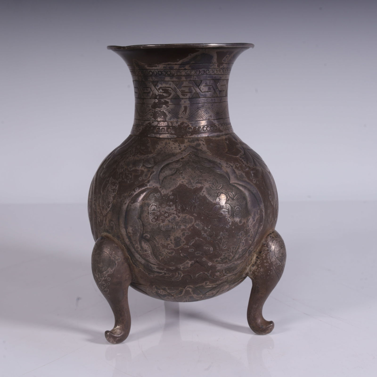 A piece of silver, engraved pattern, three-legged shape, bottle full of cloth patterns, reflecting: Silver, engraved patterns, three-legged shape, and the bottle body is full of cloth patterns, reflecting the exquisite craftsmanship of Tang Dynasty silverware, which is a furnishing or practical uten