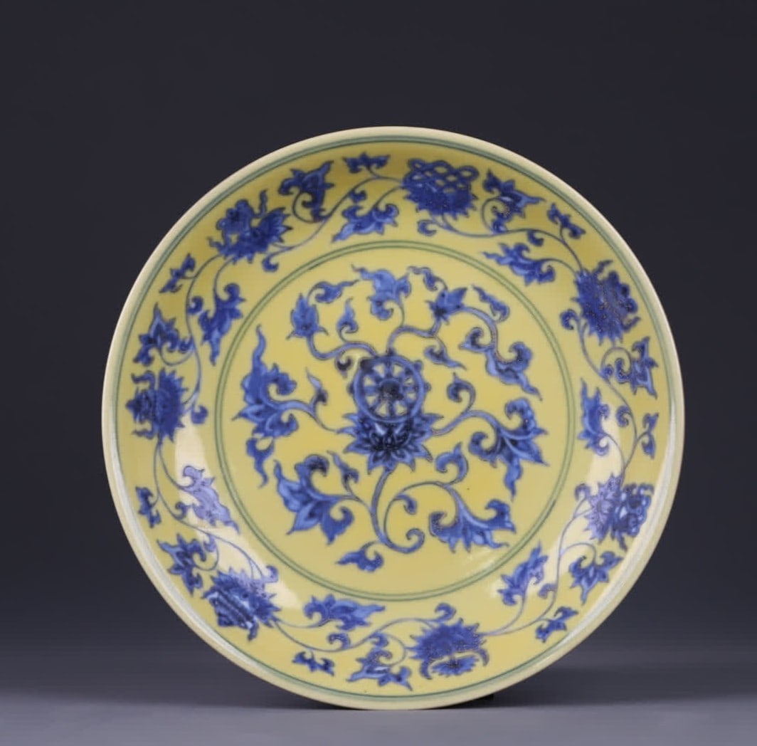 A yellow blue and white entwined lotus pattern plate made in the Chenghua era of the Ming Dynasty: Daming Chenghua year system yellow background blue and white entwined lotus pattern plate center painted wheel pattern outer wall ring decoration entwined lotus pattern branches and leaves curl smooth