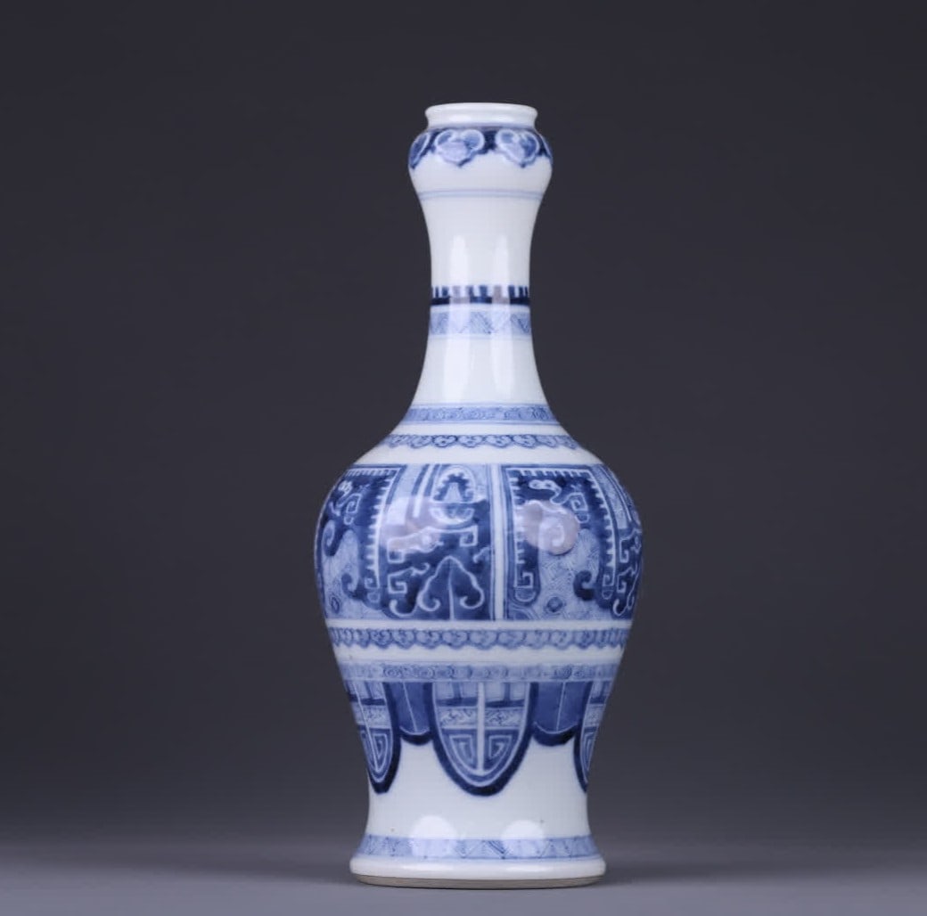A Qing Kangxi blue and white imitation bronze pattern garlic vase: Qing Kangxi blue and white imitation bronze pattern garlic bottle The whole is the classic garlic bottle shape of garlic mouth, long neck, bulging belly, and circle feet, the lines are smooth and stra