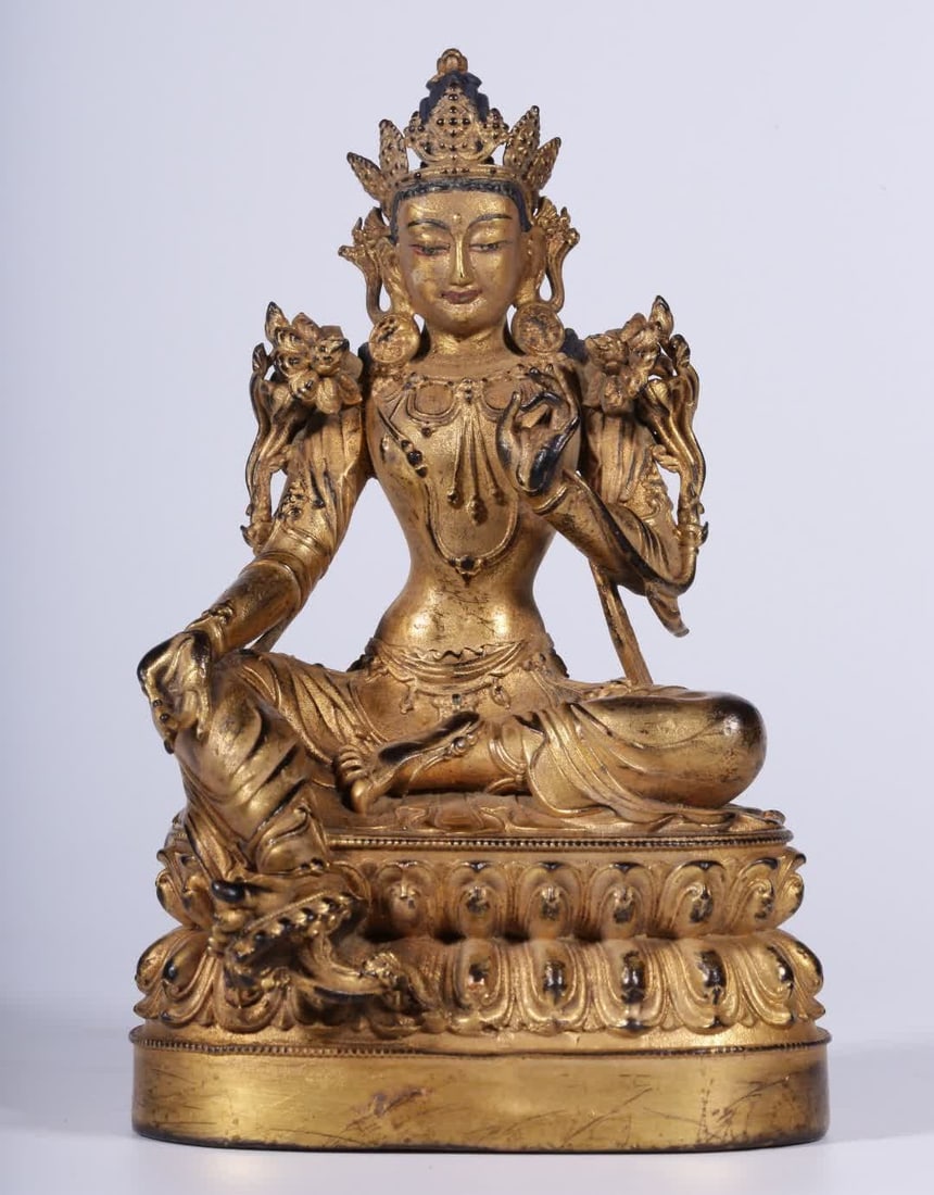 A seated statue of Tara, a bronze gilt green Tara, from the Qing Dynasty: Qing Dynasty copper gilt green Tara seated statue This green tara is cast in fine copper with excellent copper and gilded all over Tara wears a crown The face is dignified and peaceful Gentle and beau