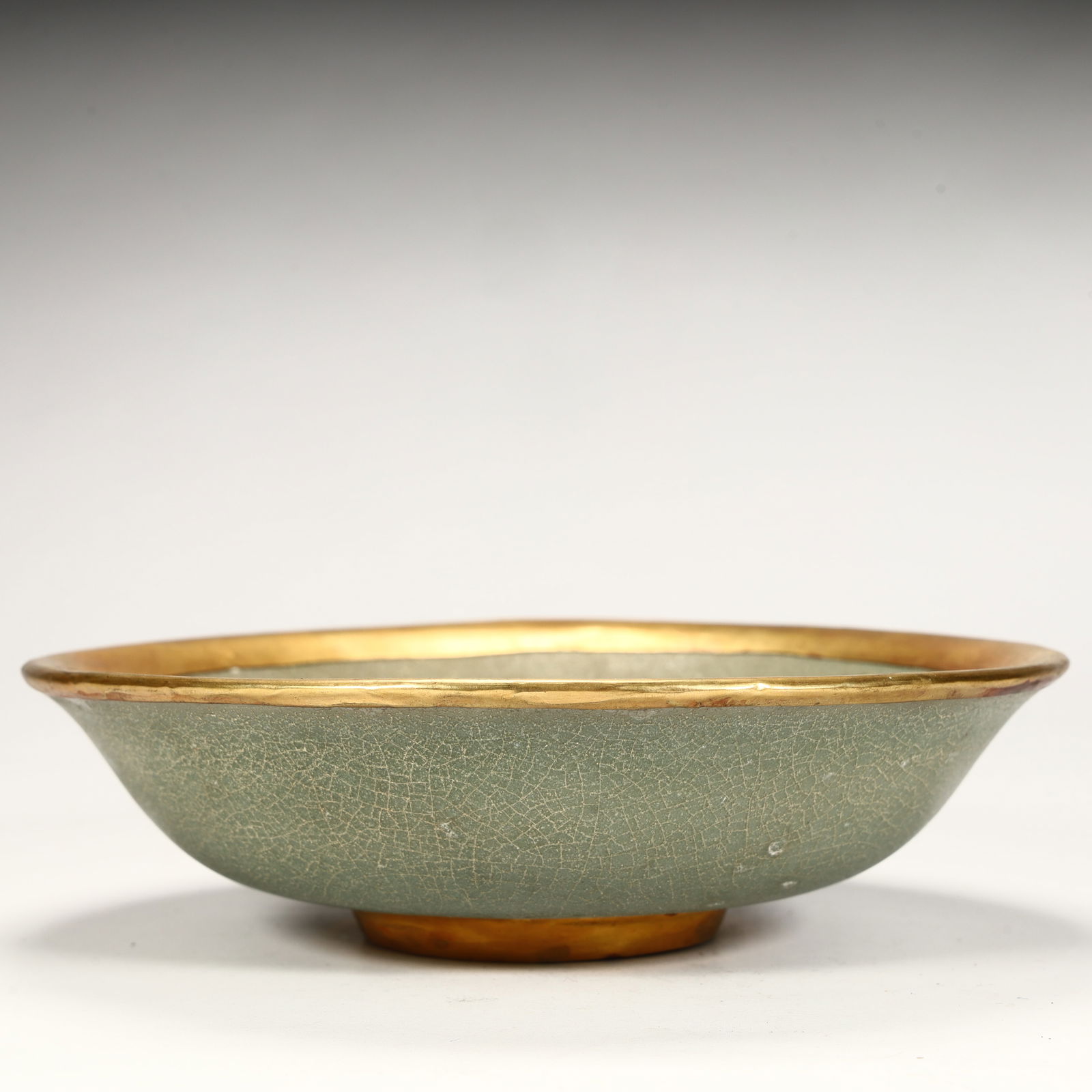 A piece of celadon porcelain, with a natural opening, gilded edges and bottom feet, and a dignified: Celadon porcelain, natural opening, gilded mouth and bottom foot, dignified bowl shape, is a practical and ornamental utensil in the Song Dynasty SIZE: H:5cm L:17.5cm W:17.5cm W:450g (The
