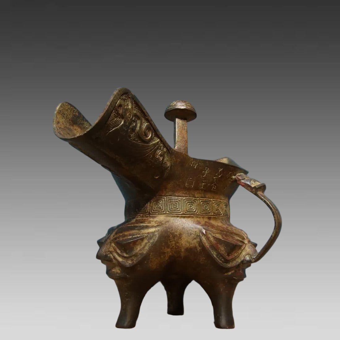 A bronze human face corner cup - 2