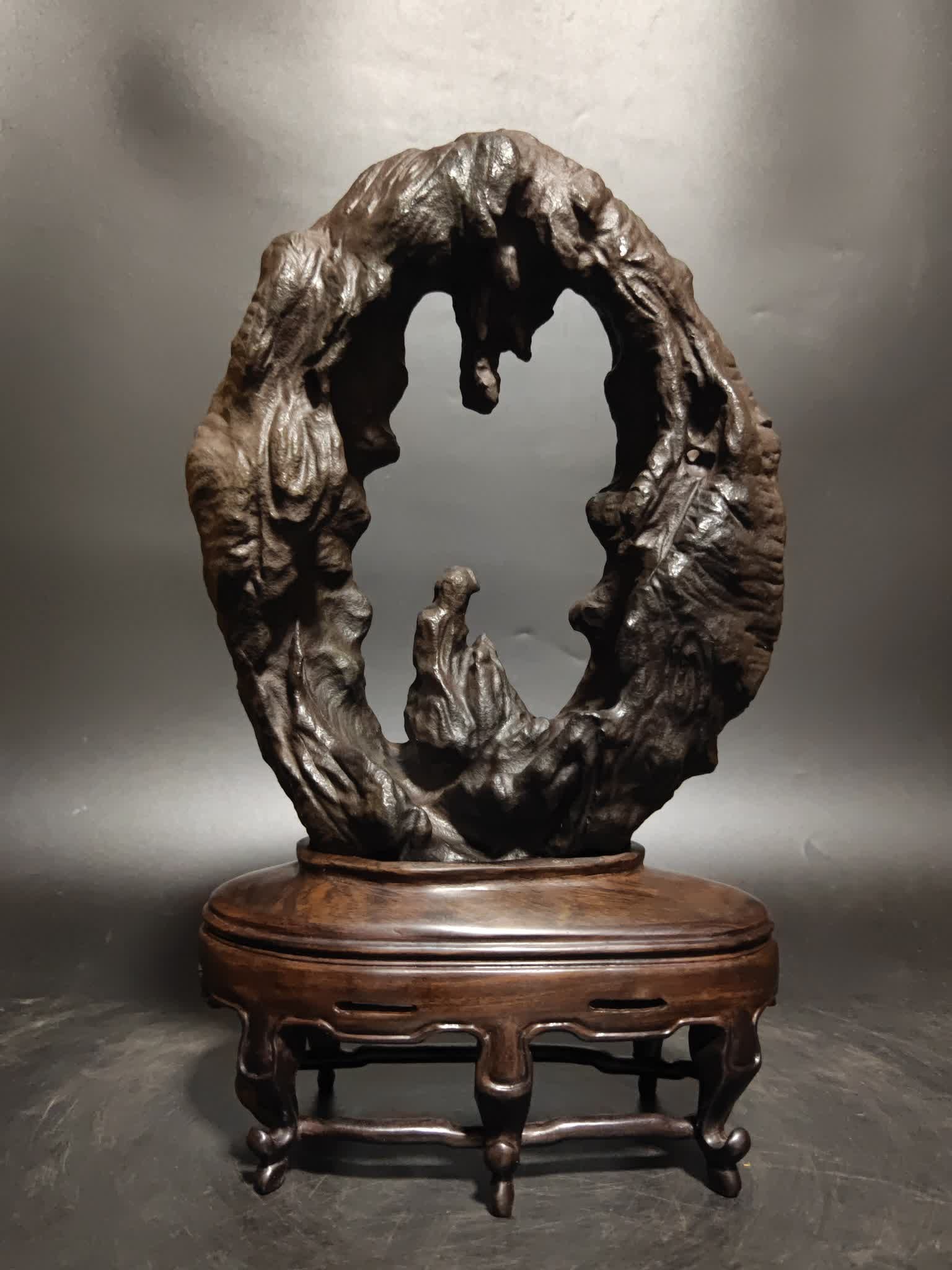 A Qing Dynasty Lingbi stone "Edge" study ornament: Qing Dynasty Lingbi Stone "Edge" Ornament This Lingbi stone ornament is like a poem carved by the years, the simple color is blurred with the traces of time, the circular shape is like a quiet window 