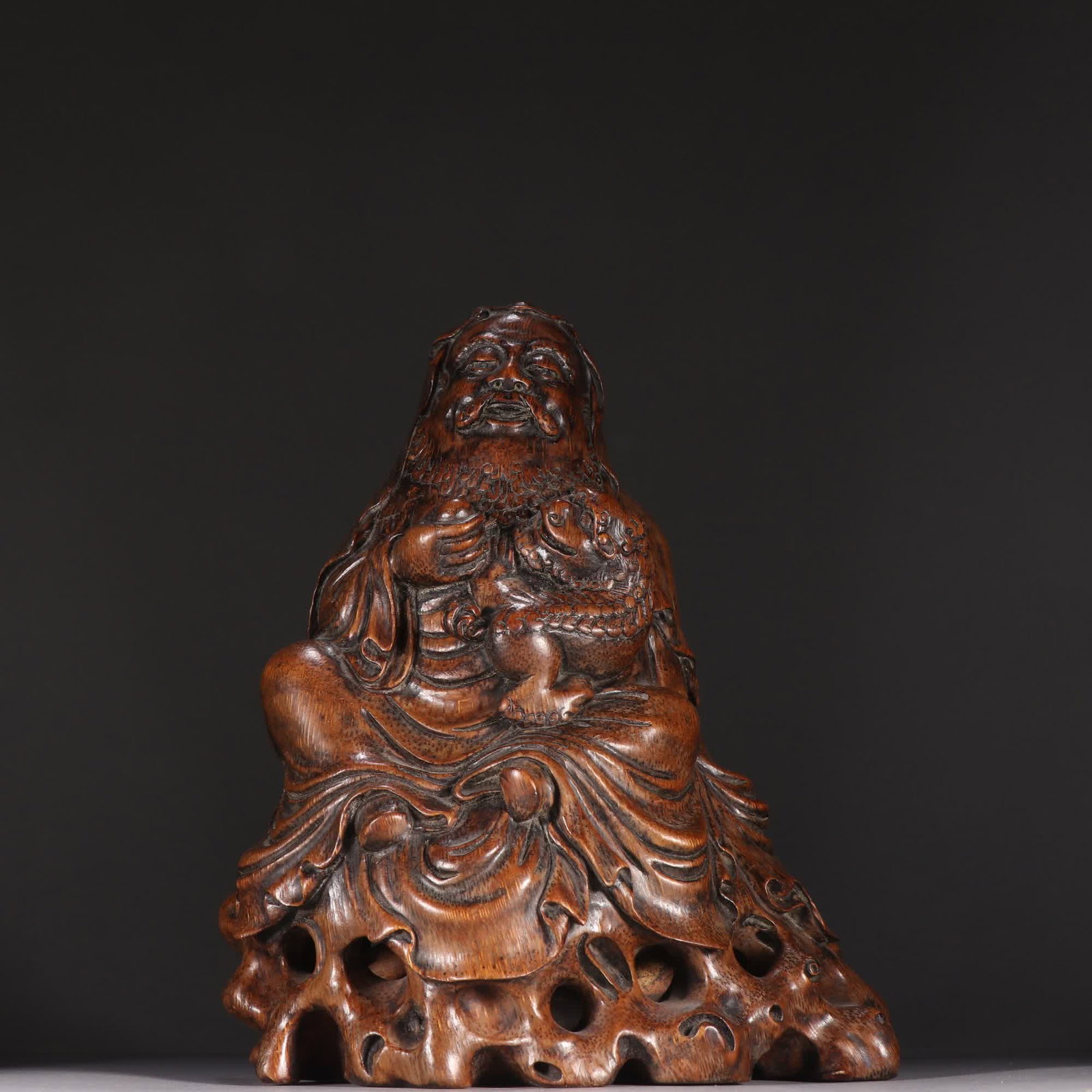 A Qing dynasty bamboo sculpture of an arhat playing with a lion (1 of 9)