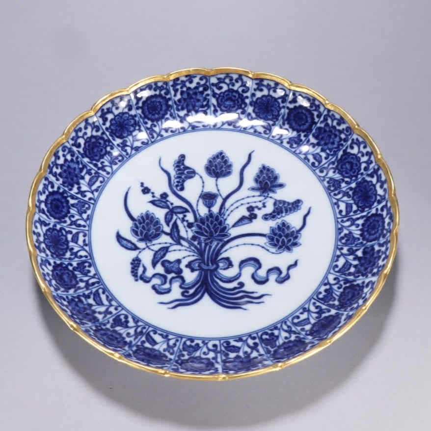 A Qing dynasty blue-and-white gold-plated "A Handful of Lotus" with a palm-leaf rim: Qing dynasty blue-and-white gold-plated "A Handful of Lotus" with sunflower pattern on the mouth plate SIZE: H:4.3cm W:23cm (The Dimensions Of All Batches Are Manually Measured.If You Need More Detail