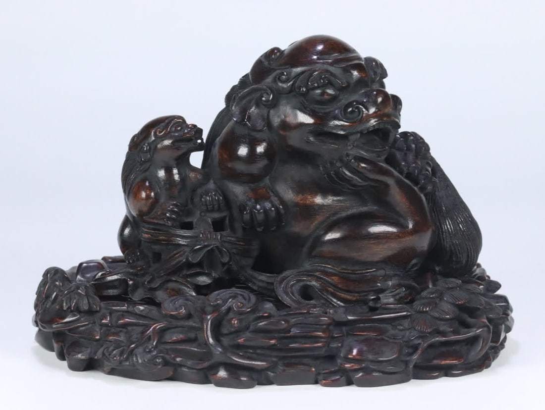 A Qing Dynasty old agarwood Grand Preceptor's young lion ornament with a rosewood base: Qing Dynasty old agarwood Grand Preceptor young lion ornament with a rosewood base SIZE: 11x16.7x10.7cm W:594g (The Dimensions Of All Batches Are Manually Measured.If You Need More Detailed Informatio