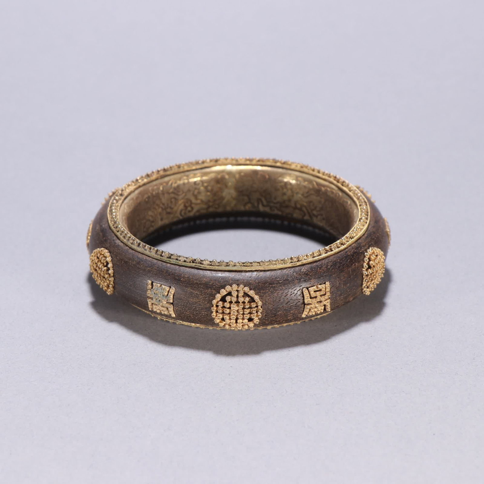 A Qing dynasty agarwood bag with a golden longevity character pattern: Qing dynasty agarwood enveloped gold longevity character pattern bracelet SIZE: Inner diameter 6cm W: 1.9cm W: 60g (The Dimensions Of All Batches Are Manually Measured.If You Need More Detailed Inform