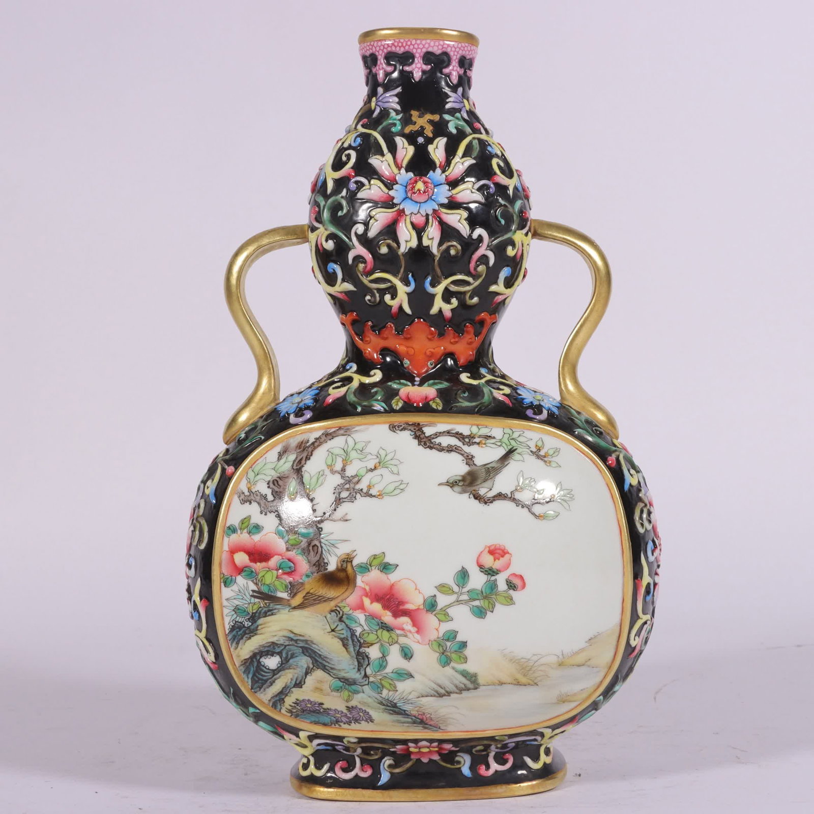 A Qing Dynasty Qianlong period enamel black lotus flower and bird gourd vase with entwined lotus: Qing Dynasty Qianlong period enamel black ground entwined lotus flower and bird gourd vase with window blooms SIZE: H: 22cm Belly diameter 13cm (The Dimensions Of All Batches Are Manually Measured.If 