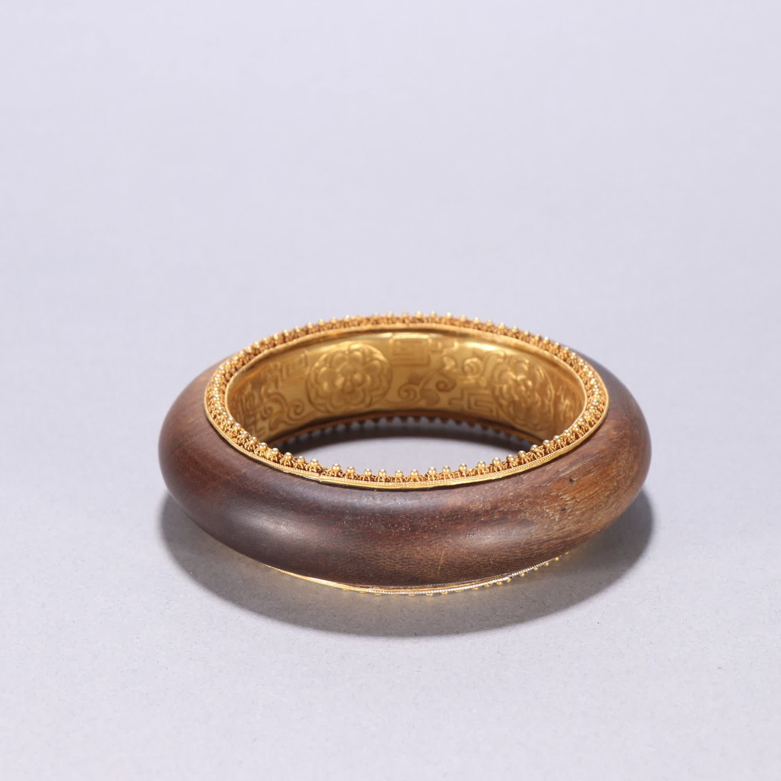 A pure Qing agarwood gold-wrapped bracelet: Qing Dynasty: Agarwood gold-plated bracelet SIZE: Inner diameter 5.8cm W: 2.2cm W: 56.7g (The Dimensions Of All Batches Are Manually Measured.If You Need More Detailed Information, Please Contact Our