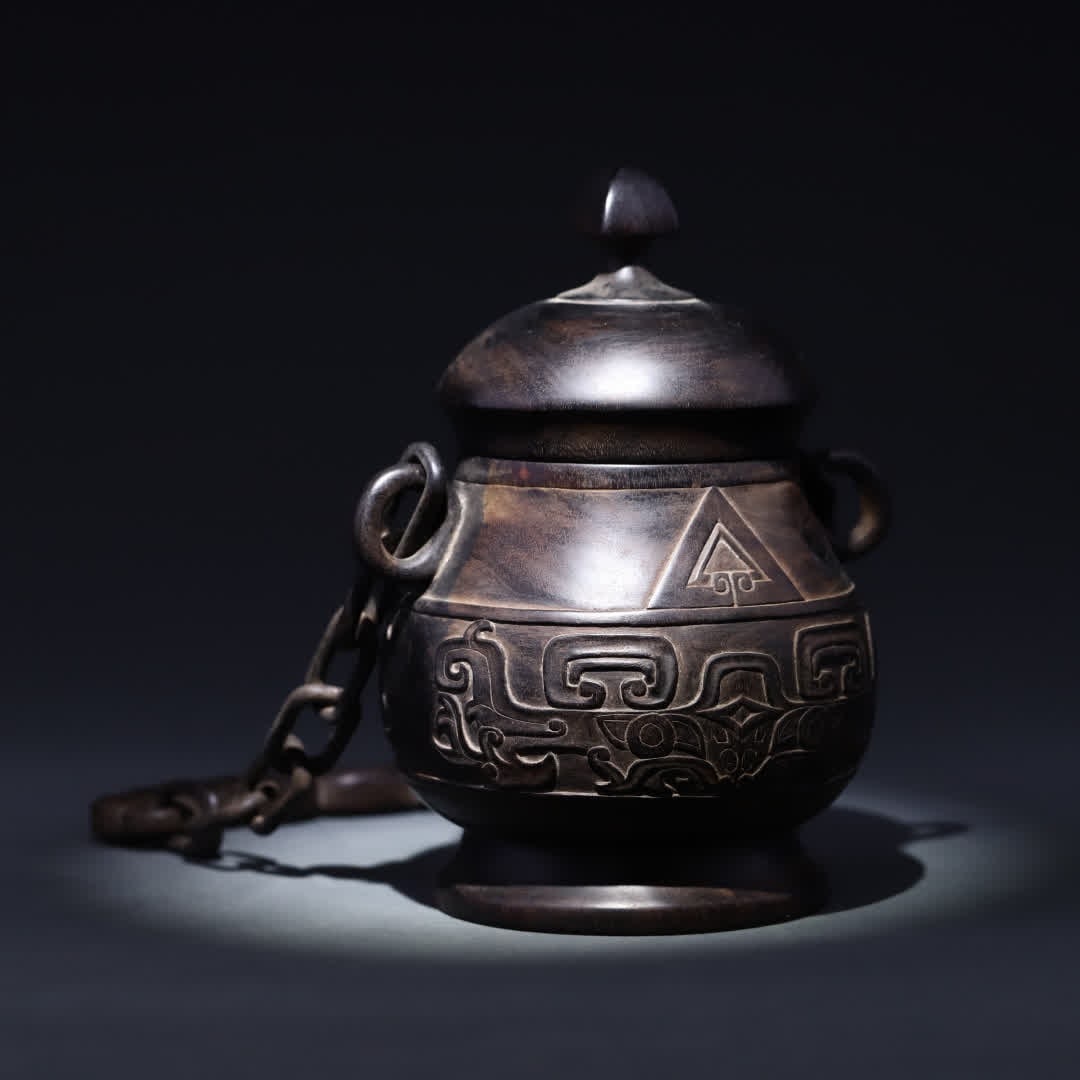 A Qing Dynasty rosewood jar with a bronze pattern featuring a movable chain lifting and lid: Qing dynasty rosewood jar with a movable chain lid decorated with bronze patterns SIZE: Total chain H: 31.8 x Can H: 19.5 x 12 cm W: 806.2g (The Dimensions Of All Batches Are Manually Measured.If You 