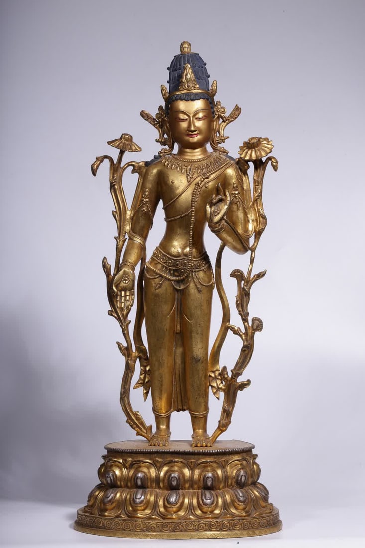 A Qing Dynasty gilded bronze standing statue of Guanyin holding a lotus in silver: A standing statue of Guanyin holding a lotus in gilded silver bronze from the Qing Dynasty SIZE: H:51cm L:23cm W:14.5cm W:7263g (The Dimensions Of All Batches Are Manually Measured.If You Need More De