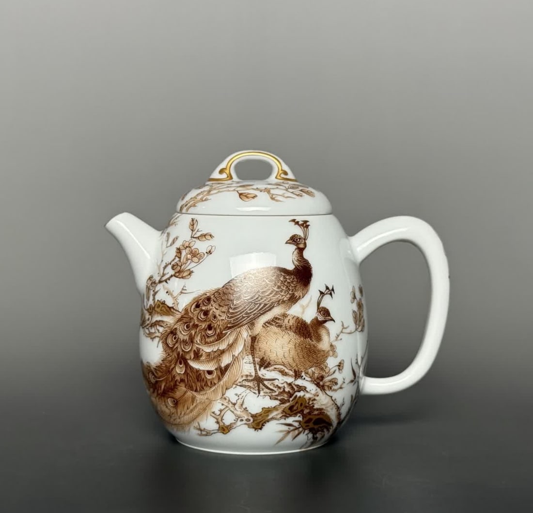 A teapot made during the Yongzheng period with sauce-colored and gilded patterns, bordered with: A teapot made during the Yongzheng period with sauce-colored and gilded patterns, bordered by peacocks inscribing poetry SIZE: Mouth D: 4.5cm H: 8.6cm Belly diameter 7cm Base diameter 4.5cm (The Dimen