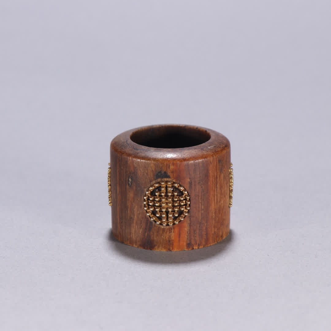 A Qing Dynasty agarwood ring with silver gilt and longevity pattern on agarwood: Qing Dynasty Agarwood Inlaid Silver Gilded Longevity Pattern Thumb Ring SIZE: Inner diameter 2.3cm W: 3cm W: 19.4g (The Dimensions Of All Batches Are Manually Measured.If You Need More Detailed Inform