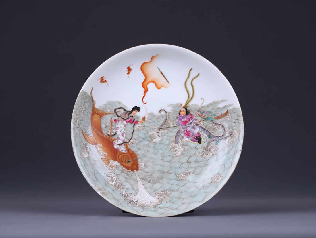 A Qing dynasty Qianlong period famille rose Nezha Stirring the Sea Plate: Qing Dynasty Qianlong Period Famille Rose Nezha Stirring Sea Tray features a classic plate with an open mouth, shallow belly, and ring foot. The shape is regular and full, with smooth and rounded line