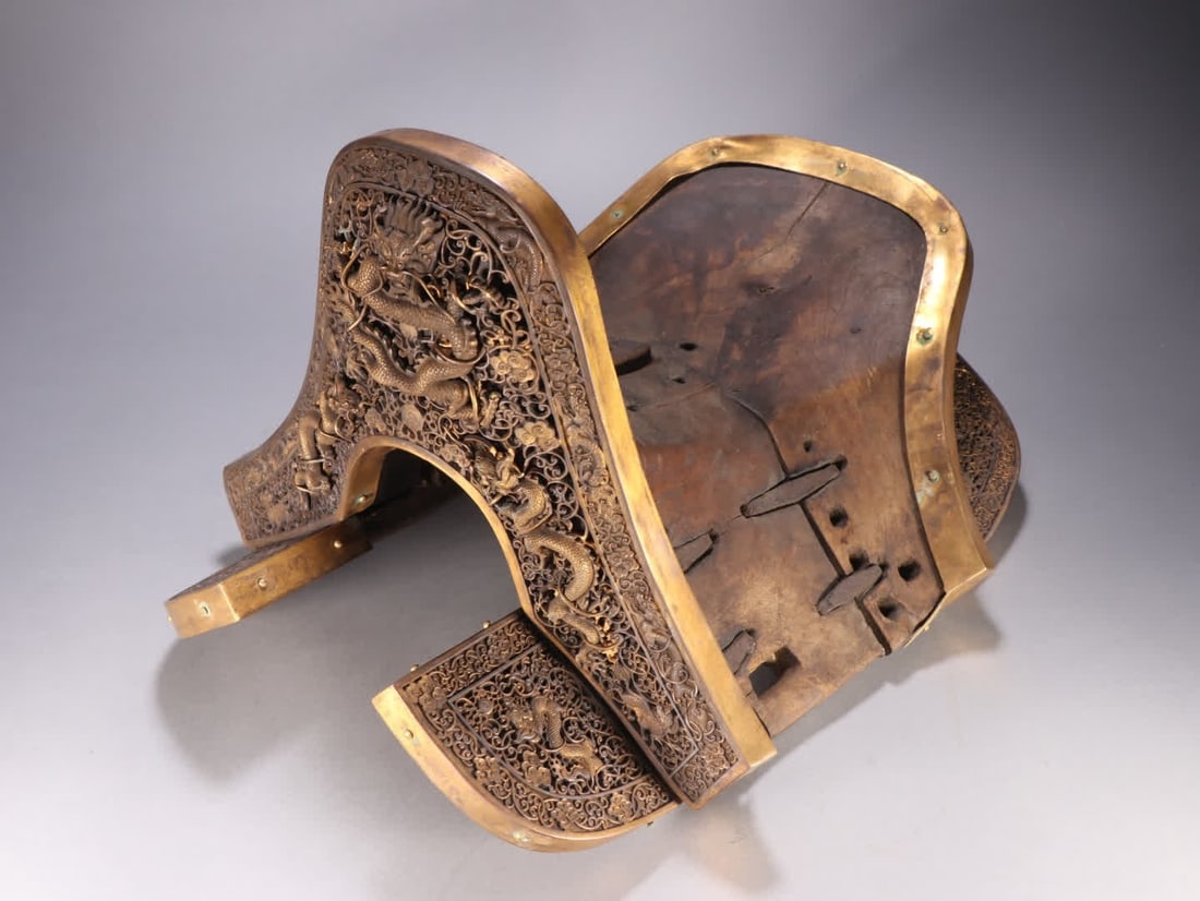 A Qing Dynasty bronze saddle inlaid with cherry wood dragon patterns: Qing Dynasty bronze gilt inlaid cherry wood dragon pattern saddle SIZE: H:26.5cm W:42cm W:5.2kg (The Dimensions Of All Batches Are Manually Measured.If You Need More Detailed Information, Please