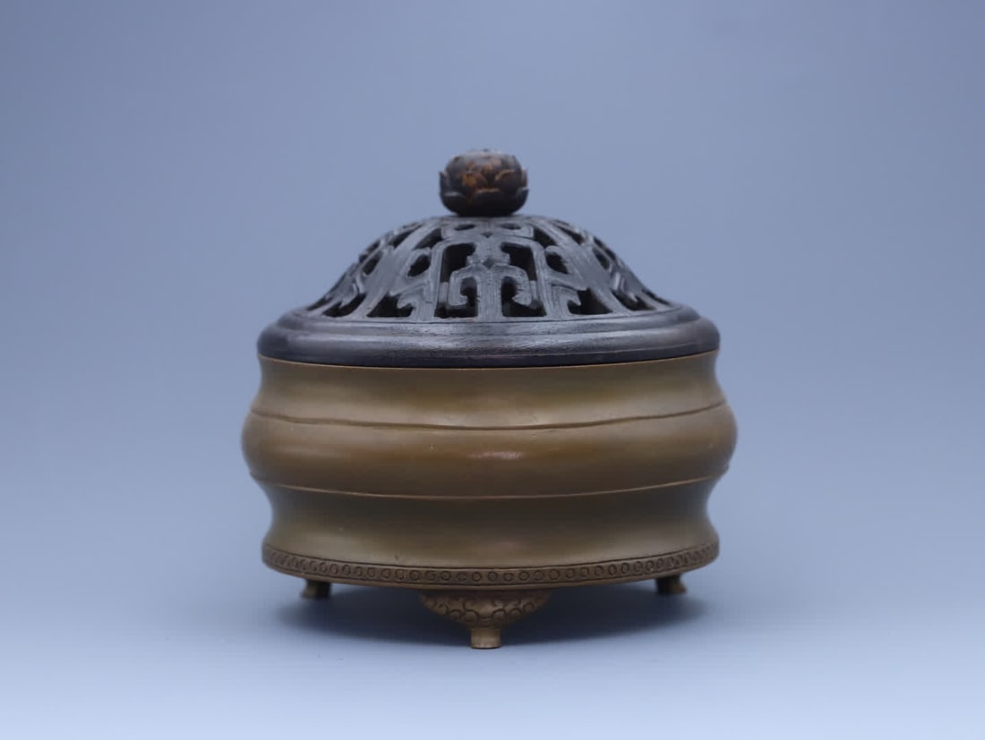 A piece of Qing dynasty A bronze three-legged censer made during the Xuande period of the Ming: Qing Dynasty The Bronze Three-Legged Burner with Metal Handle made during the Xuande period of the Ming Dynasty has a body made of refined brass, cast using the lost-wax method. The body is thick and 