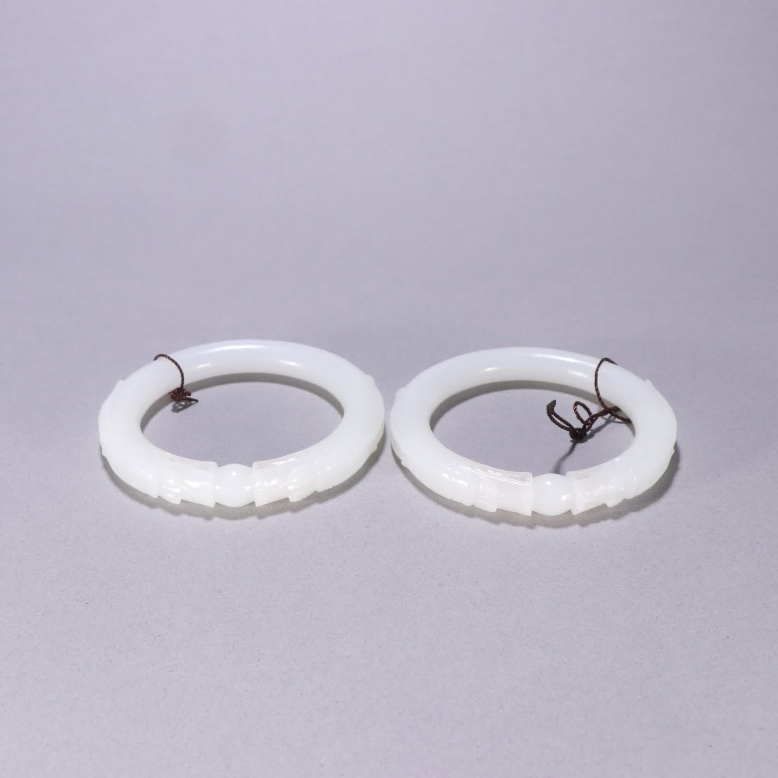 A pair of Qing Dynasty Hetian jade bracelets featuring two dragons playing with pearls: A pair of Qing Dynasty Hetian jade bracelets featuring two dragons playing with pearls SIZE: Inner diameter 5.8cm, W: 1.2cm, Total W: 114.8g (The Dimensions Of All Batches Are Manually Measured.If You