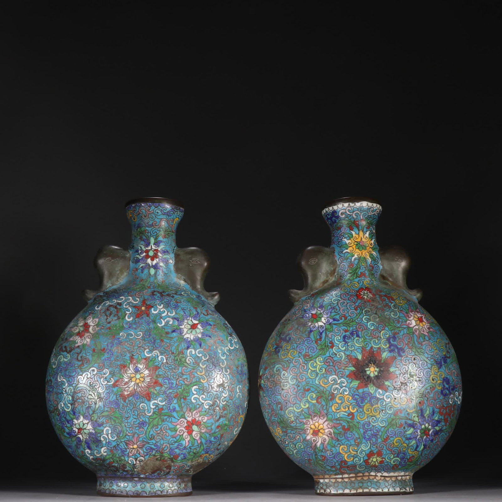 A pair of Qing Dynasty cloisonne entwined floral vases with elephant ear moon embraces: A pair of cloisonne entwined floral vases from the Qing Dynasty, with elephant ears embracing the moon SIZE: H:23cm W:15.6cm W:2292.3g (The Dimensions Of All Batches Are Manually Measured.If You Need 