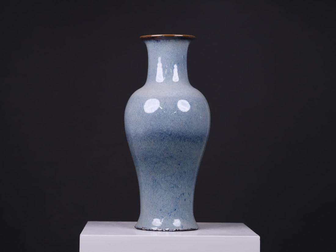 A Qing Dynasty kiln-glazed Guanyin vase: Qing Dynasty Kiln-Glazed Guanyin Vase: The entire bottle body is kiln-changed glazed, with a light blue base color that blends with varying shades of blue spots. The glaze surface is lustrous and glos