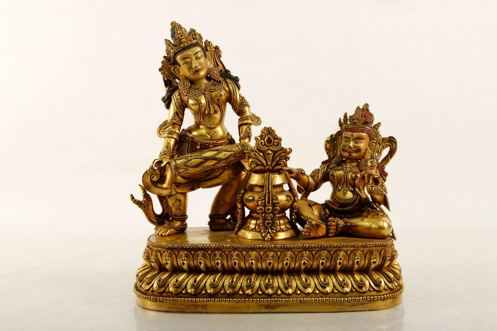 Gilt Bronze Statues: Gilt Bronze Statues. The two figures with a Buddhistic treasure bottle in the center are set upon a double lotus base, wearing robes decorated with beaded rims, each holding ritual items. Mark of Yong