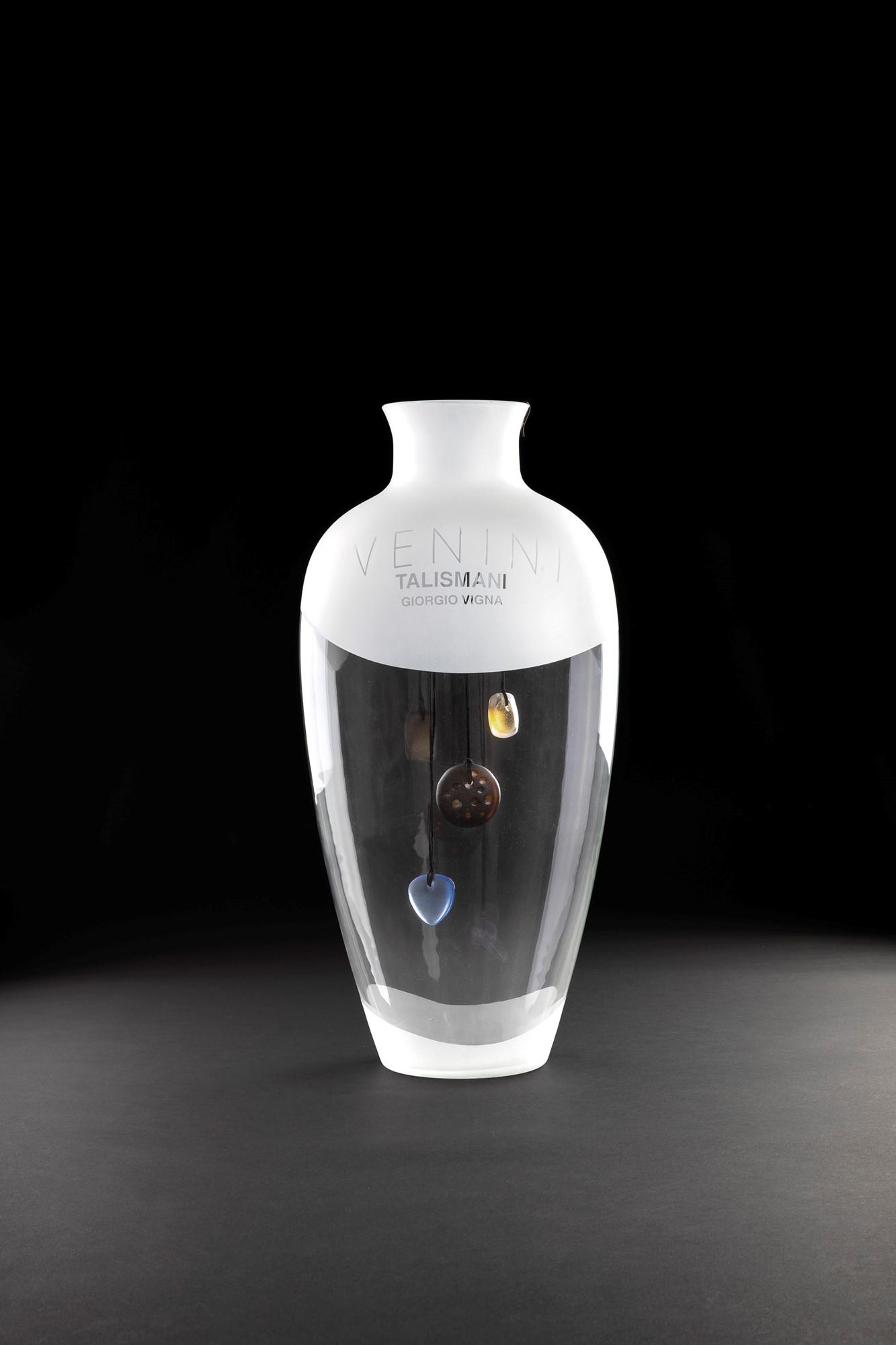Giorgio Vigna. Talismani (Sole, Luna, Cuore) entro grande vaso espositore: Pendenti gioiello Sole, Luna, Cuore della Collezione Talismani Vetro soffiato inciso e molato. Grande vaso espositore originale in vetro soffiato cristallo. Venini, 1990 ca. h cm 62, diam. cm 28 Bibli
