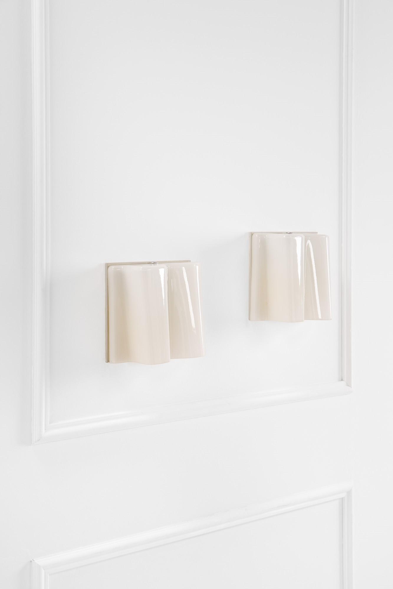 Michele De Lucchi, Gerhard Reichert, Coppia di lampade da parete mod. Logico mini: Coppia di lampade da parete mod. Logico miniVetro lattimo sagomato, metallo verniciato.Prod. Artemide, 2000 ca.Etichetta del produttore.cm 22,5x25x11