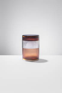 Paolo Venini - Massimo Vignelli. Vaso cilindrico con coperchio e fascia in argento: Vaso cilindrico con coperchio Vetro corniola a più strati di colore, rifinito da sottili incisioni. Fascia in argento alla sommità del vaso. Venini, 1957 - 1963 Marchio "Italia Christofle". Etichett