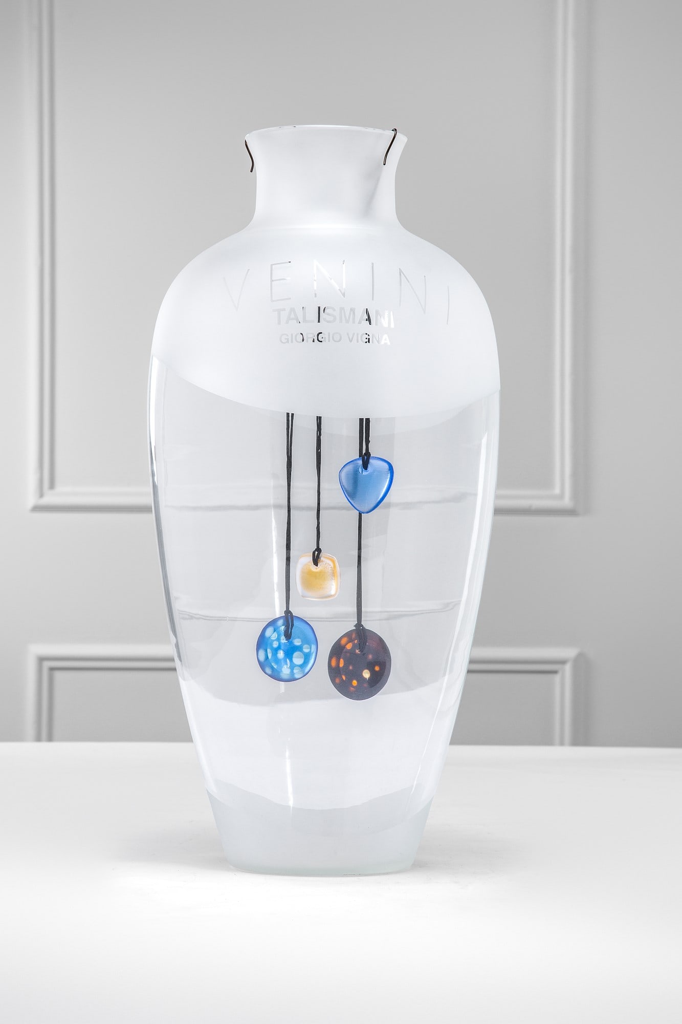 Giorgio Vigna. Quattro pendenti gioiello della Collezione Talismani: Sole, Luce e due Luna Quattro pendenti gioiello della Collezione Talismani. Vetro soffiato inciso e molato. Grande vaso espositore originale. Vetro soffiato cristallo. Venini, 1999 Firma incisa a punt