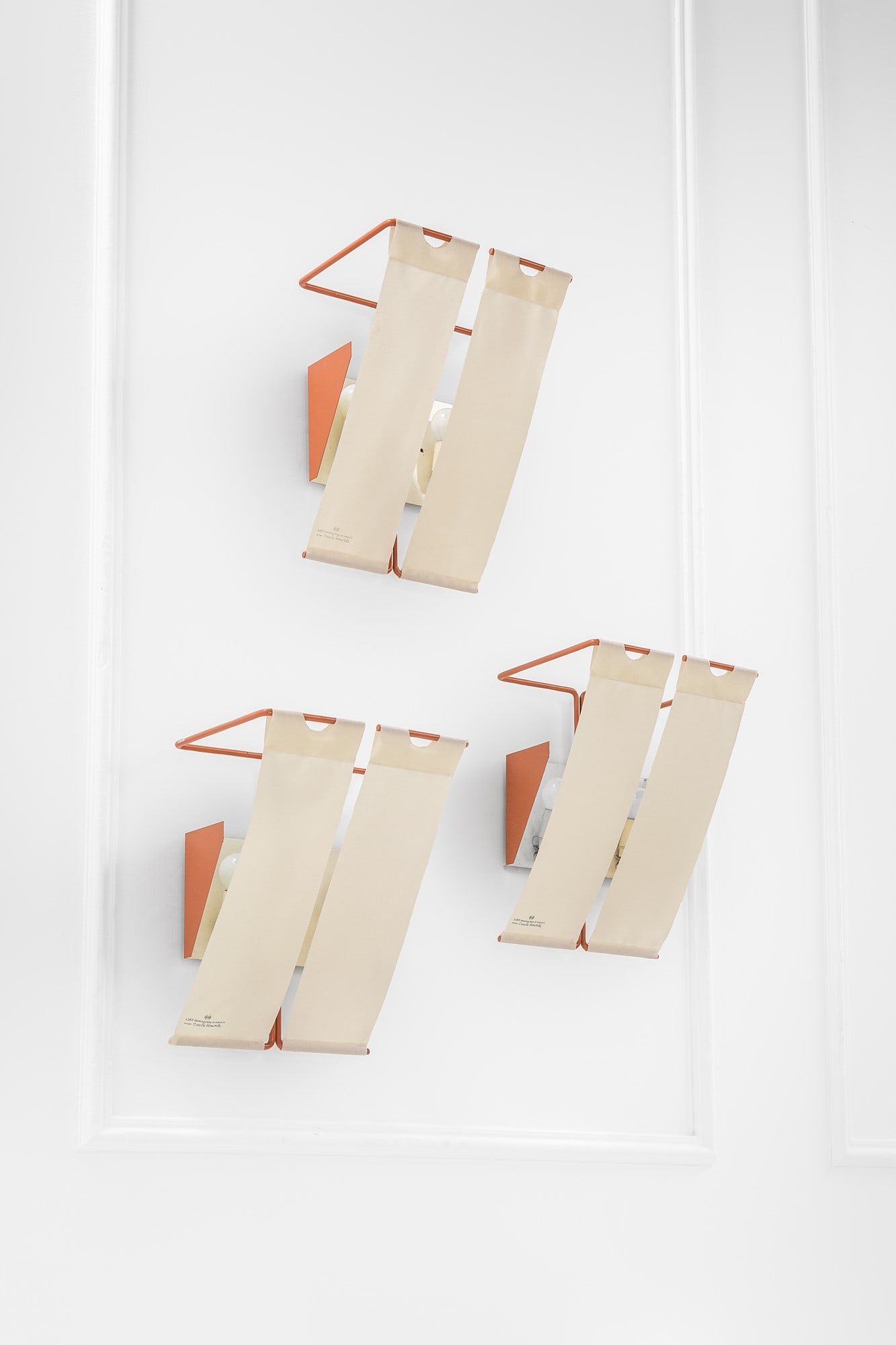 Carla Venosta. Tre lampade da parete: Tre lampade da parete Metallo verniciato, tessuto. Prod. Luci, 1970 ca. Marchio stampato sul tessuto. cm 36x29x23