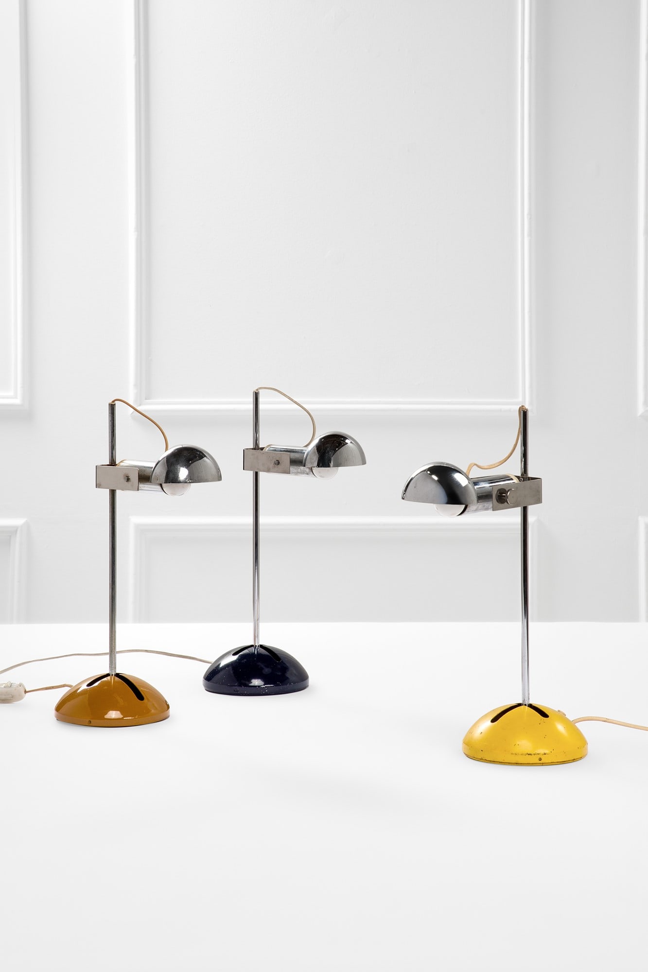 Robert Sonneman. Tre lampade da tavolo mod.T395: Tre lampade da tavolo mod.T395 Metallo verniciato, metallo cromato. Prod. Lumi, 1970 ca. Marchio del produttore. Misure variabili, h cm 50, lungh. cm 17-38, prof. cm 33-44