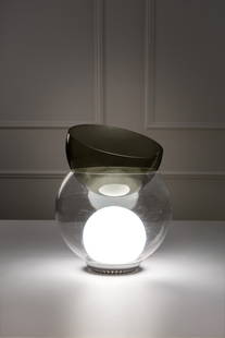 Gae Aulenti. Lampada da tavolo mod. Giova: Lampada da tavolo mod. Giova Elementi in vetro soffiato trasparente, talpa e opalino, metallo. Semisfera superiore utilizzabile come portafiori. Prod. Fontana Arte, 1964 ca. h cm 34, diam. cm 30 Liter