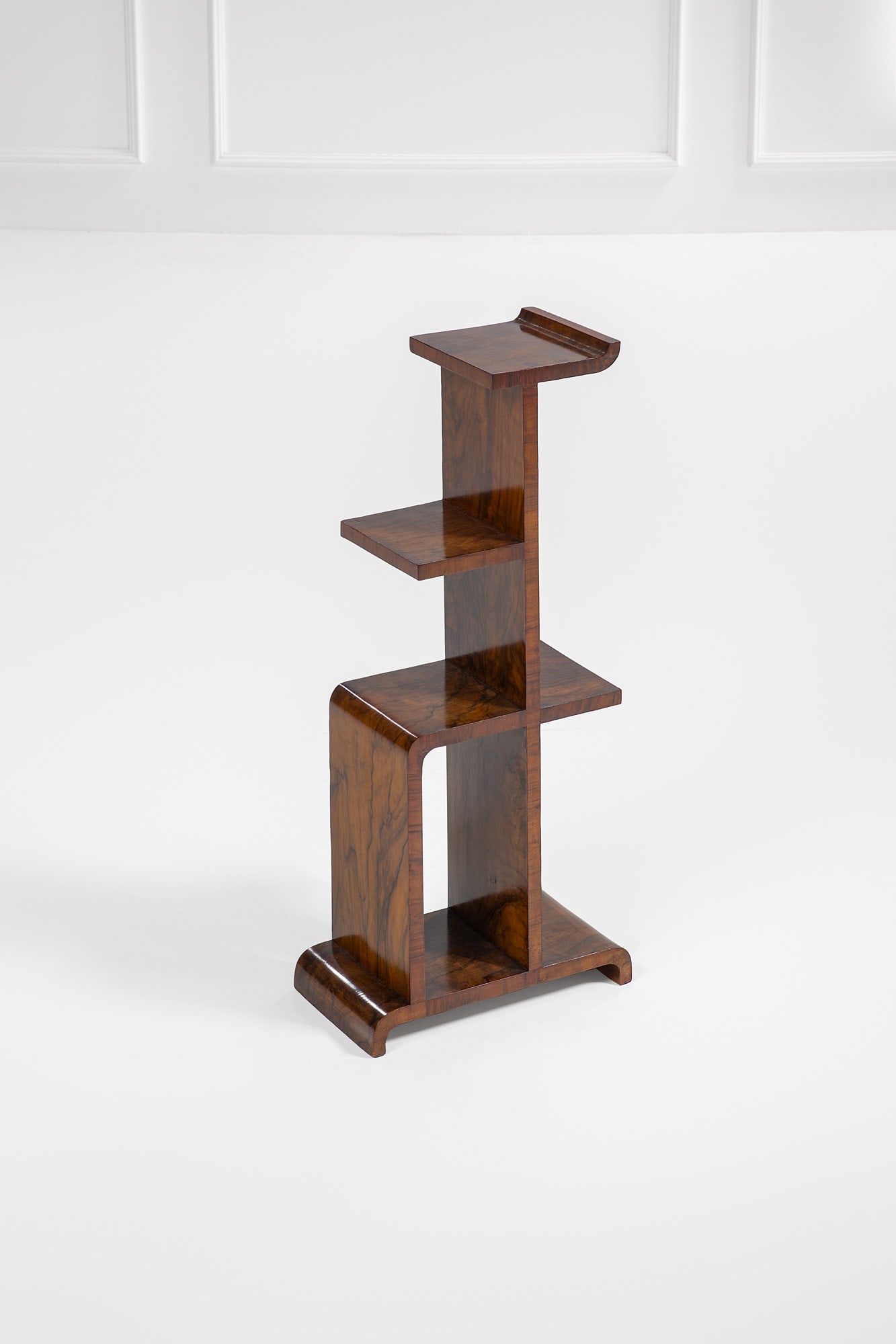 Gio Ponti, Emilio Lancia. Étagère: Étagère Legno sagomato e impiallacciato in radica. Prod. Domus Nova per La Rinascente, 1930 ca. cm 94x42x22 Literature: Immagine pubblicitaria d'epoca.