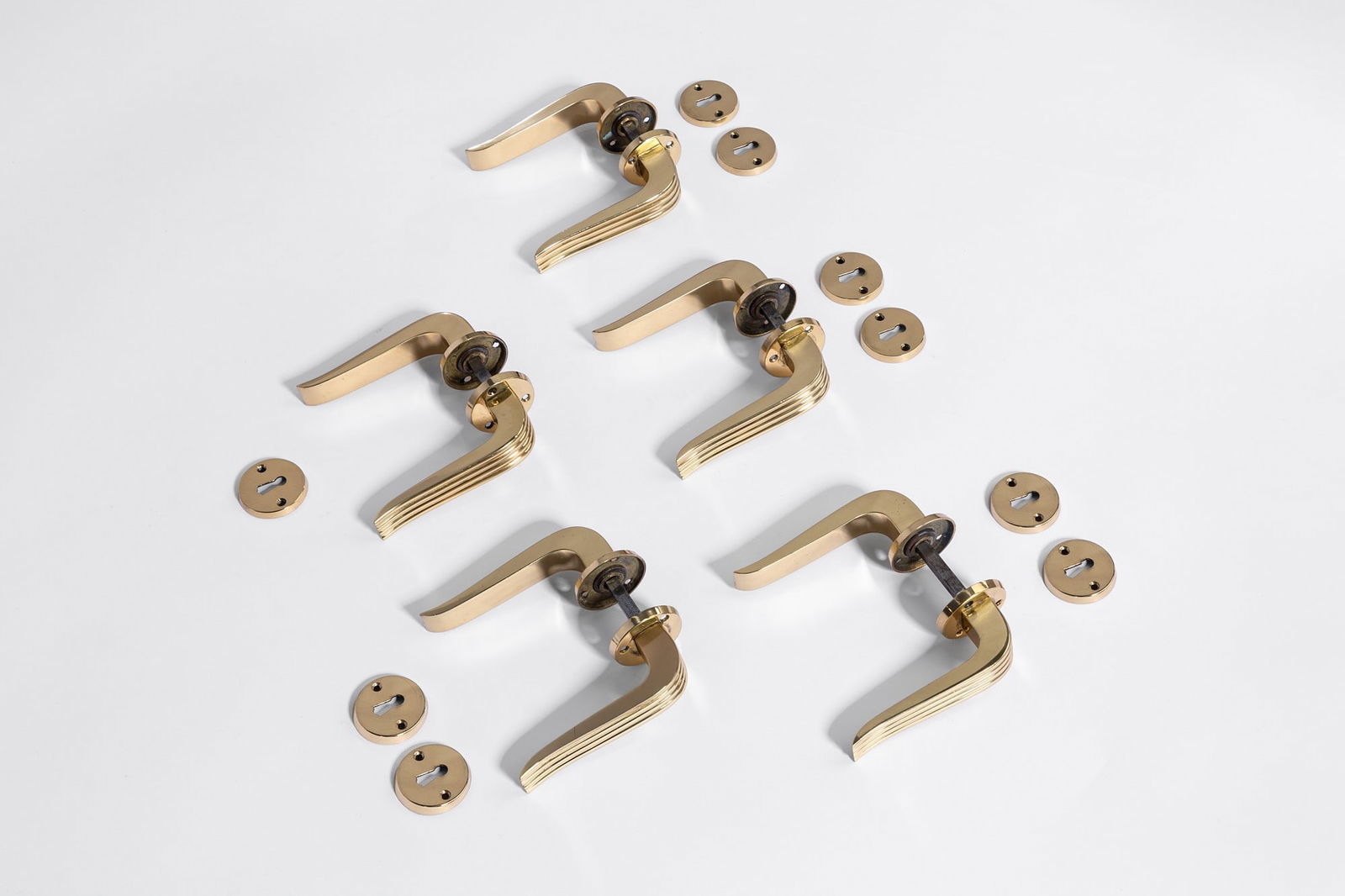 Emilio Lancia (attr.). Set di 5 coppie di maniglie: Set di 5 coppie di maniglie Fusione di ottone. 1950 ca. cm 13x13x5, bocchetta diam. cm 4