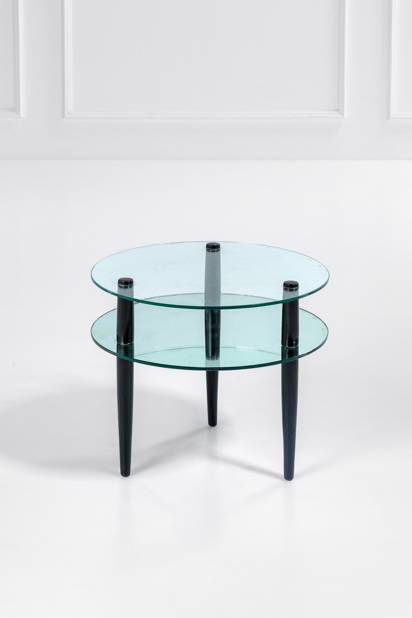 Enrico Paolucci. Tavolino a due piani circolari: Tavolino a due piani circolari Legno ebanizzato, vetro specchiato, vetro molato. 1950 ca. h cm 50, diam. cm 60