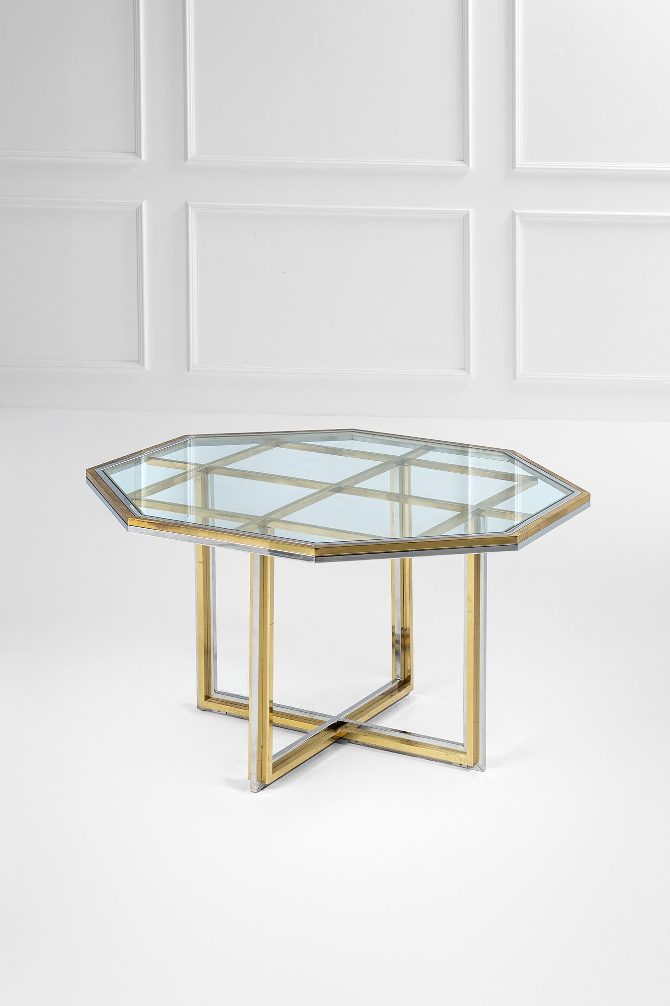 Romeo Rega, nel gusto di. Tavolo con piano ottagonale: Tavolo con piano ottagonale Metallo cromato, ottone lucido, vetro. 1970 ca. cm 75x119x119