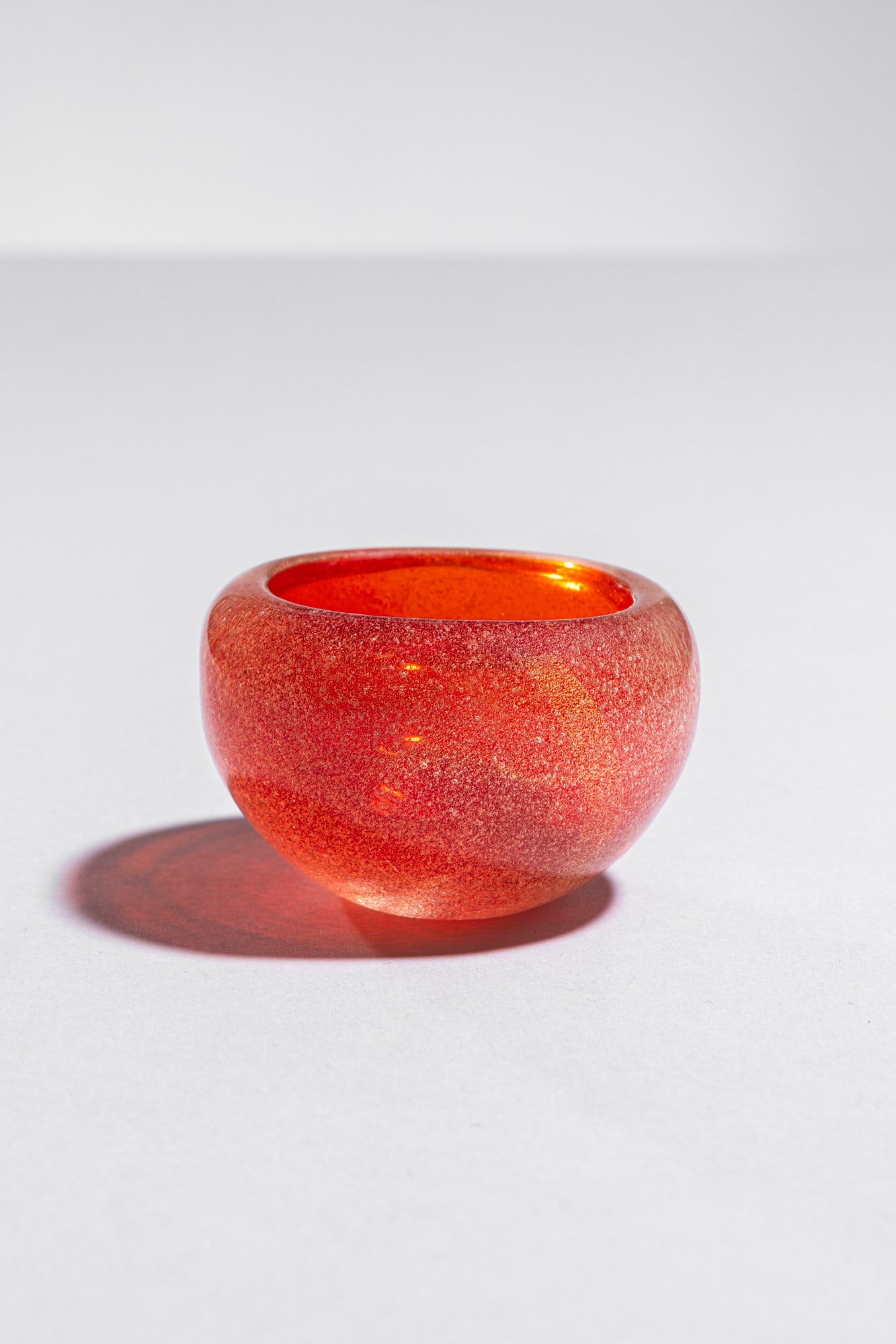 Carlo Scarpa. Coppa della serie Sommersi mod. 3528: Coppa della serie Sommersi mod. 3528 Coppa vetro soffiato aranciato con inclusione di bollicine. Venini, 1934 ca. h cm 5, diam. cm 7 Bibiliografia: Marino Barovier (a cura di), Carlo Scarpa. Venini 19