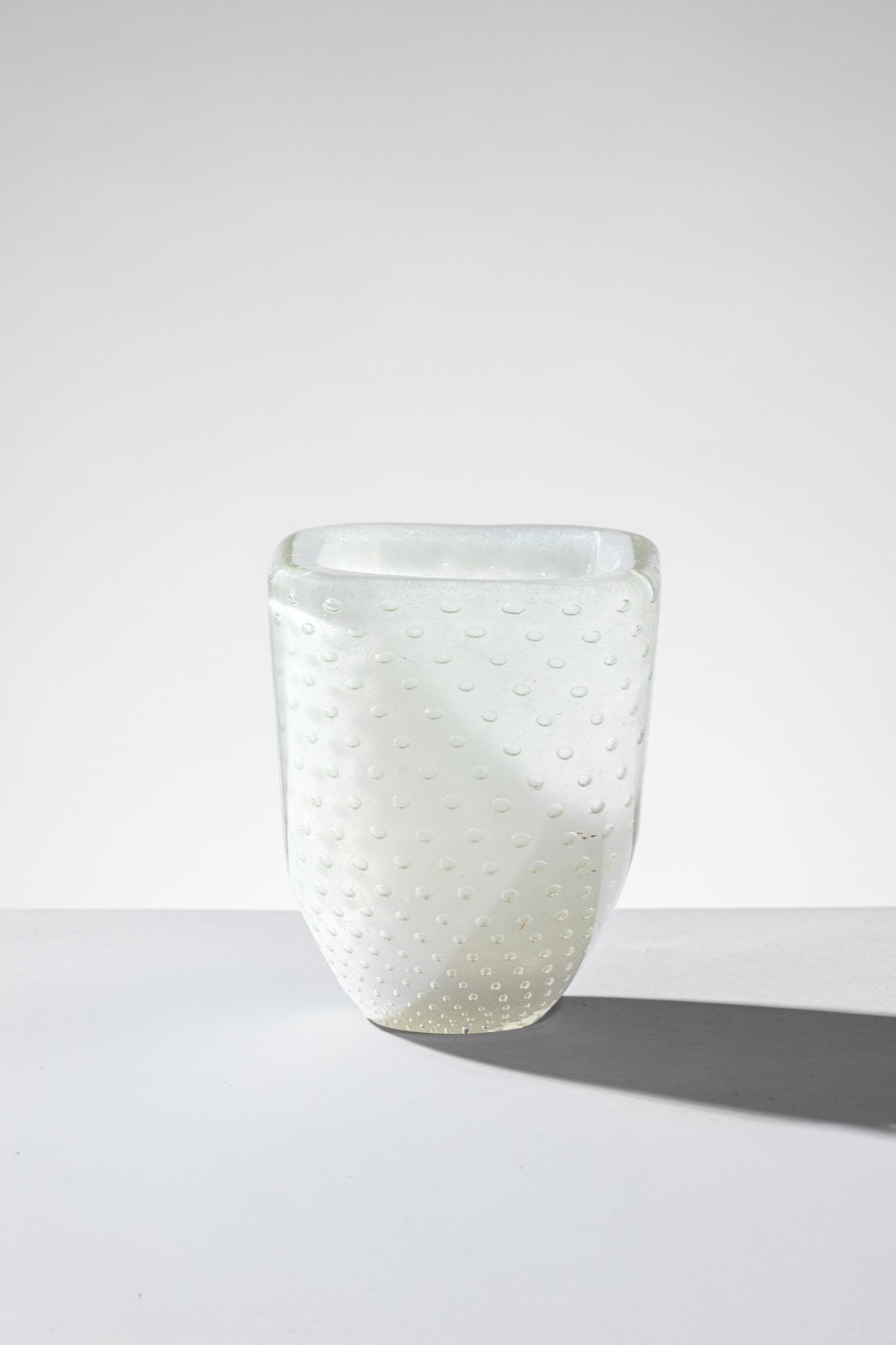 Carlo Scarpa. Coppa della serie Sommersi: Coppa della serie SommersiVetro soffiato sommerso lattimo con inclusione di bolle regolari.Venini, 1934-1936Firma all'acido Venini Murano.cm 14x12x12Bibiliografia: Marino Barovier (a cura di), Carlo